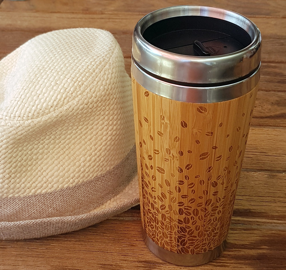 coffee beans wooden travel mug with hat on wood table